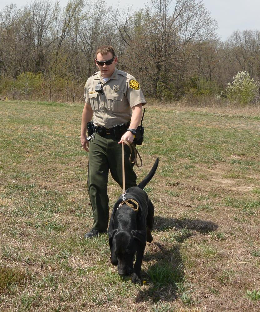 Deputy Ryan Reed holding Otis on a leash.